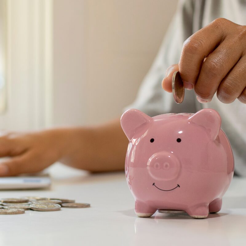 hand putting a quarter in a piggy bank